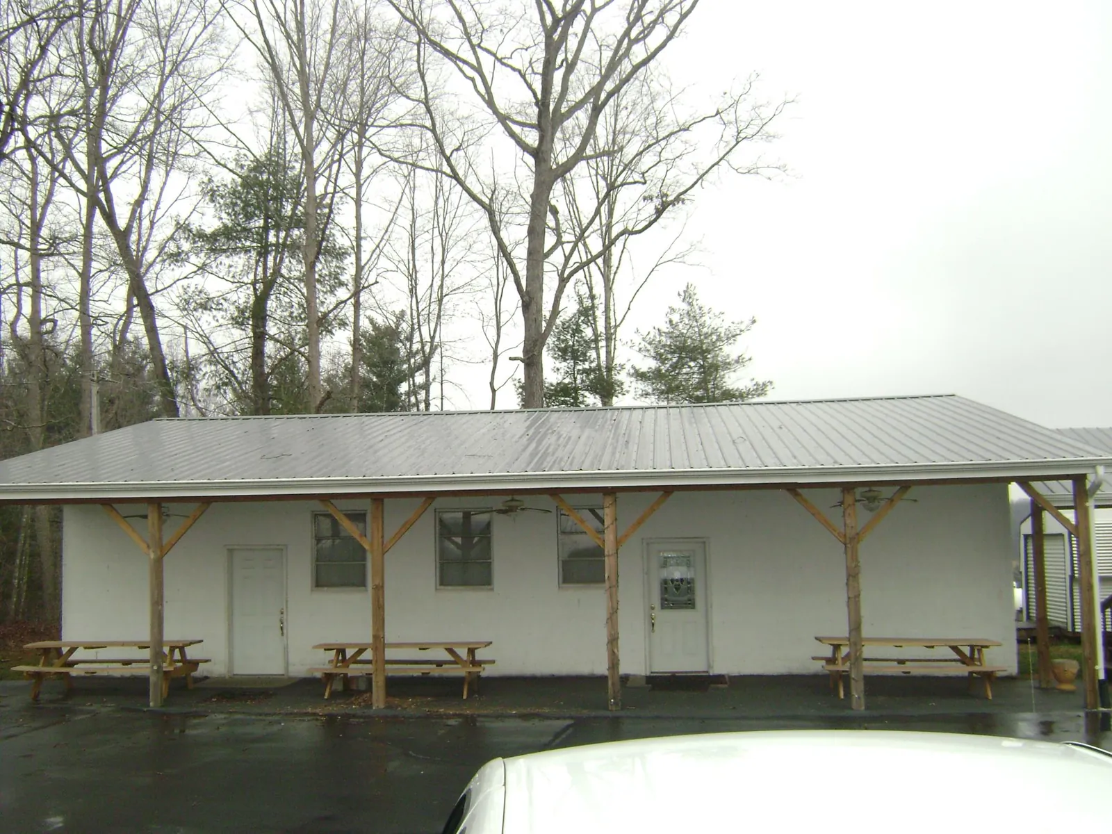 Gray metal roof over a block building with a timber post porch in Edgewater